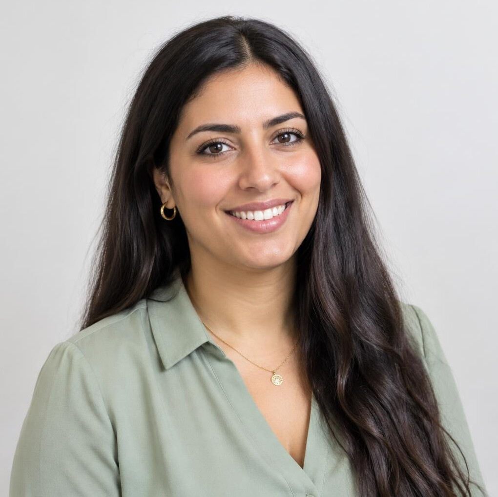 Portrait of a young woman of North African descent with long dark hair smiling